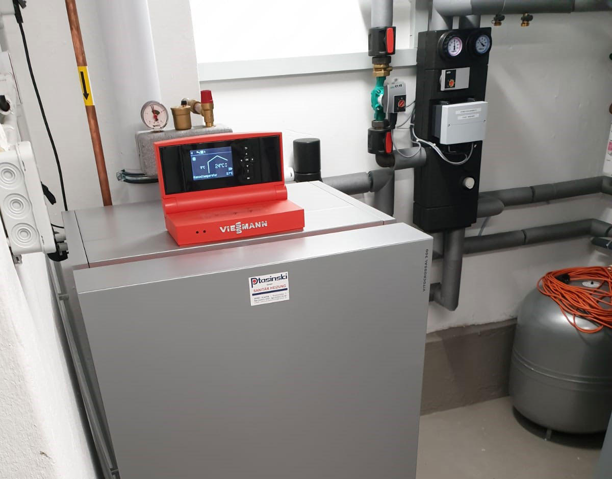 Ein Gasofen mit rotem Messgerät in einem Raum mit einer Heizung.