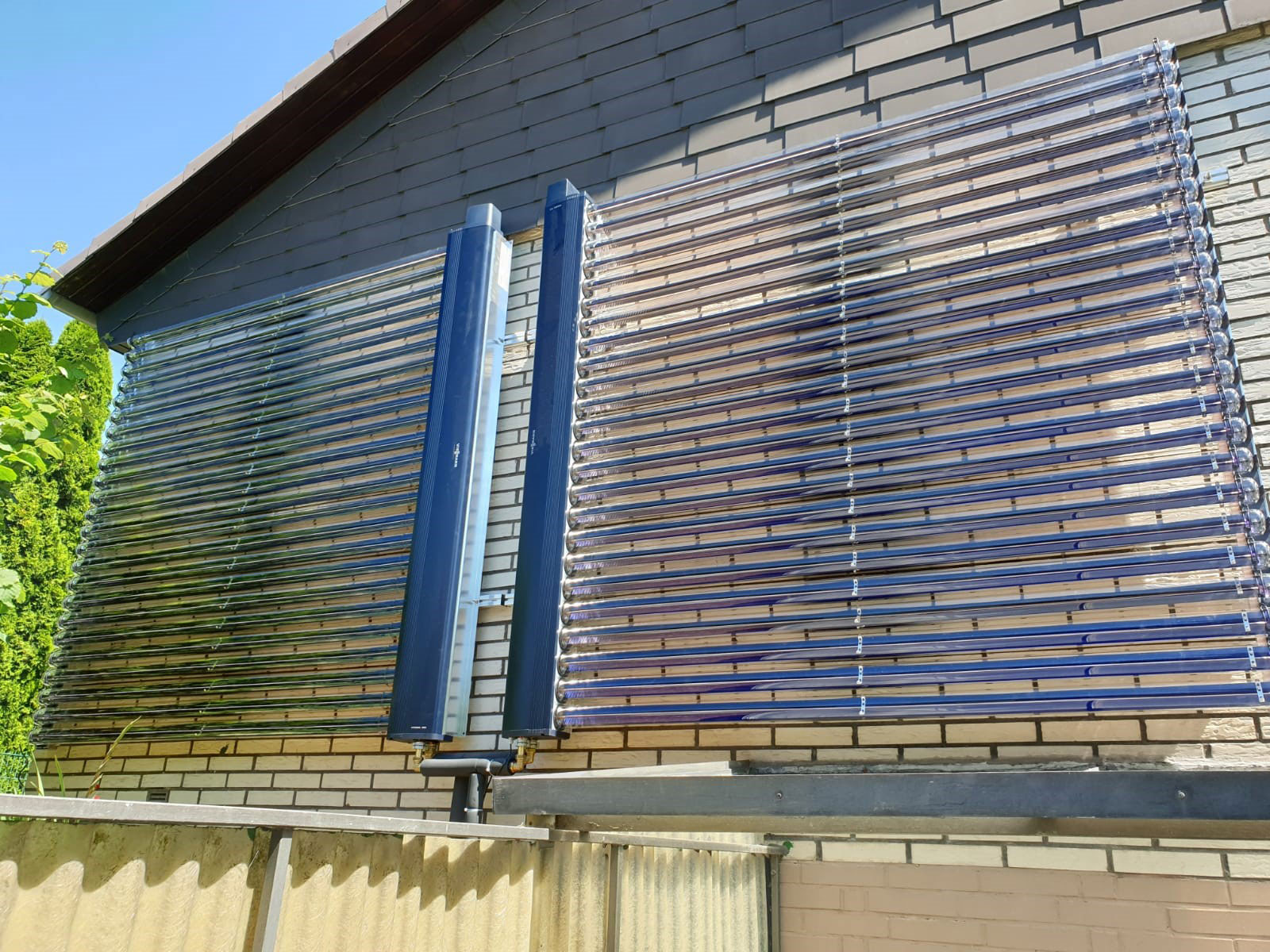 Eine blaue Solarthermie-Anlage an der Fassade eines Hauses installiert..